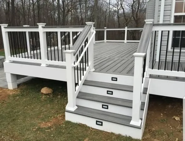 Composite deck with white railing, black balusters and lit stair risers